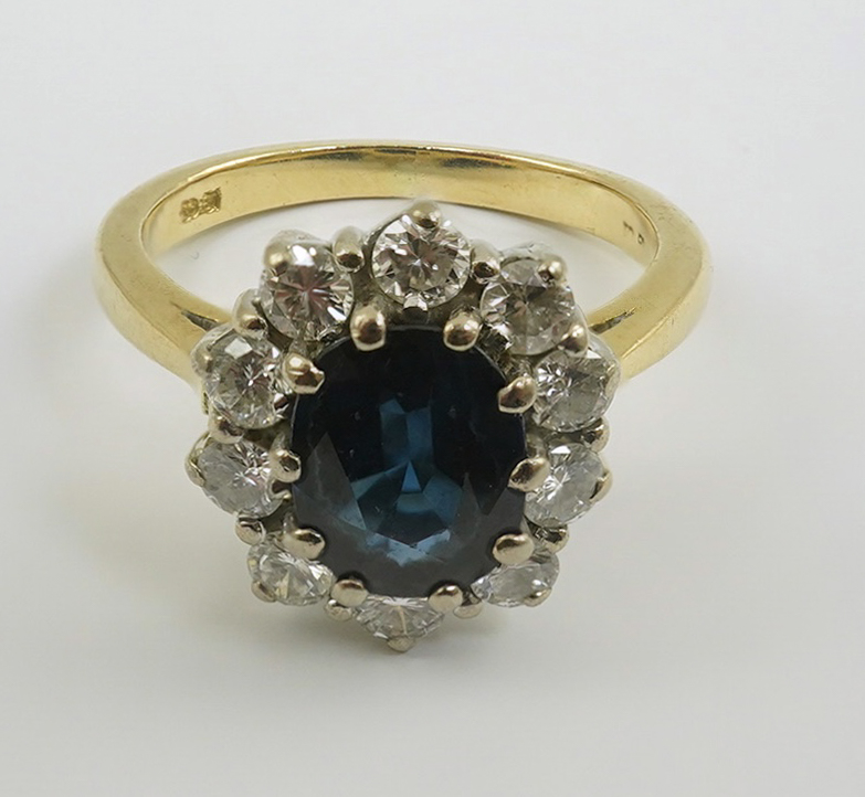 A modern 18ct gold, sapphire and diamond set oval cluster ring